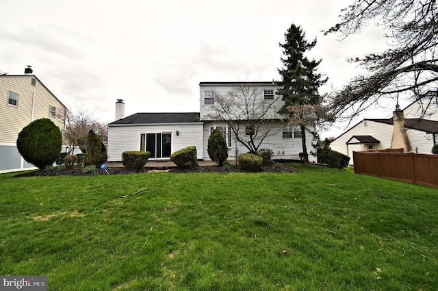 745 Champlain Dr, King Of Prussia, PA 19406 - back of house with a chimney, fence, and a lawn