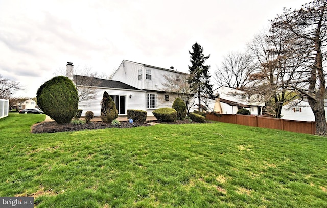 745 Champlain Dr, King Of Prussia, PA 19406 - back of house with fence, a lawn, and a chimney