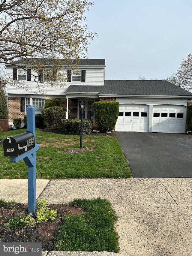 745 Champlain Dr, King Of Prussia, PA 19406 - view of front facade with a front yard, a shingled roof, an attached garage, aphalt driveway, and brick siding