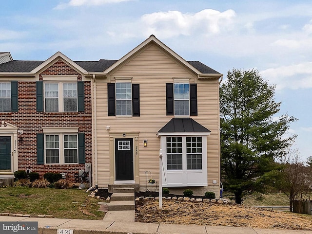view of property featuring entry steps and a front lawn