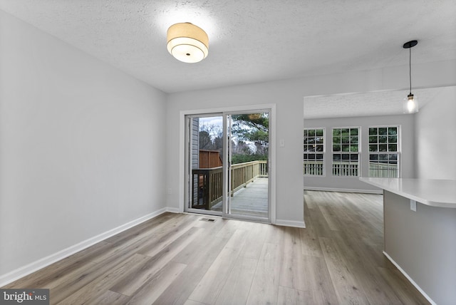 interior space featuring baseboards, wood finished floors, and a textured ceiling