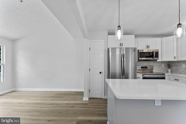 kitchen featuring light countertops, a textured ceiling, white cabinetry, stainless steel appliances, and light wood-style flooring