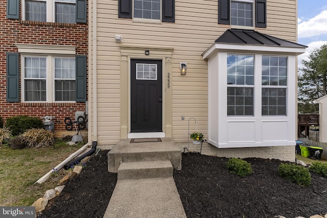 entrance to property featuring brick siding