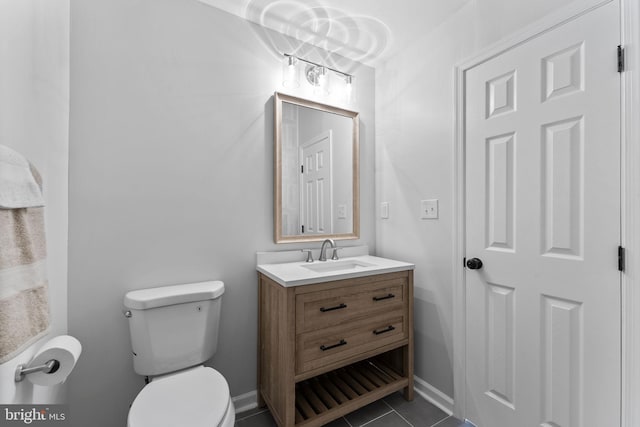 half bathroom featuring toilet, tile patterned floors, vanity, and baseboards