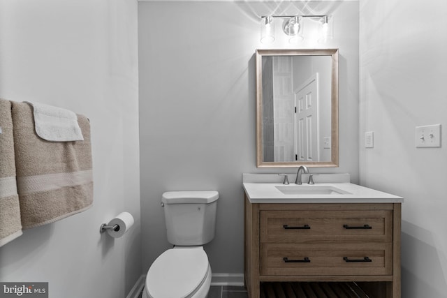 half bath featuring vanity and toilet