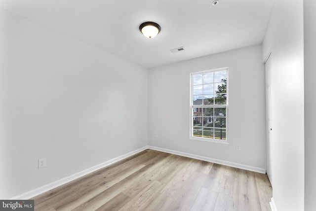 empty room with visible vents, baseboards, and light wood-type flooring