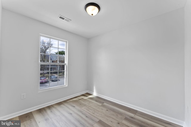 unfurnished room with visible vents, baseboards, and wood finished floors