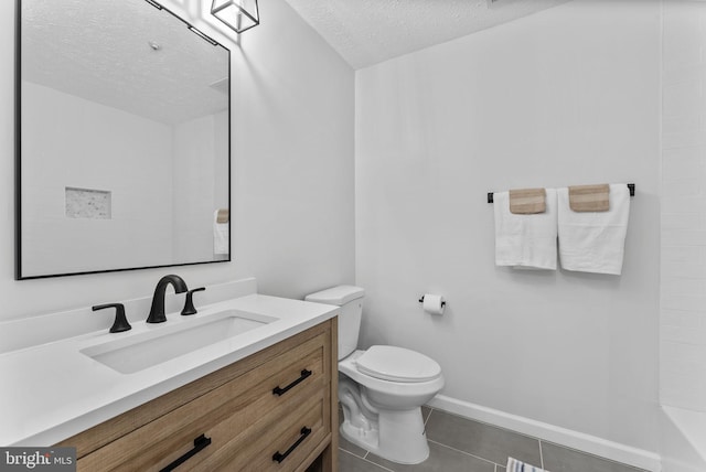full bath with a textured ceiling, vanity, toilet, tile patterned floors, and baseboards