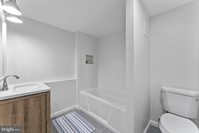 bathroom with toilet, vanity, baseboards, and tile patterned flooring