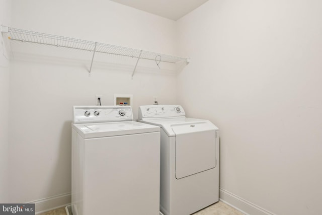 clothes washing area featuring baseboards, laundry area, and washing machine and clothes dryer