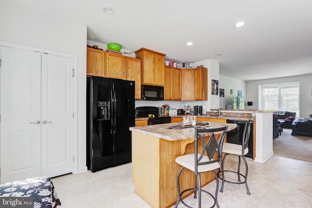 904 Emerson Ct, Clementon, NJ 08021 - kitchen with a breakfast bar area, a peninsula, open floor plan, black appliances, and light countertops