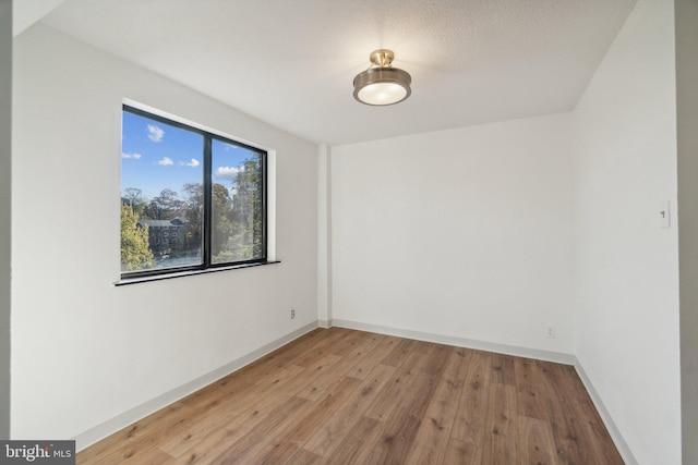 empty room featuring light wood-style flooring and baseboards