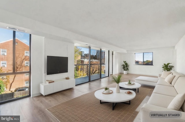 living area with visible vents, baseboards, and wood finished floors