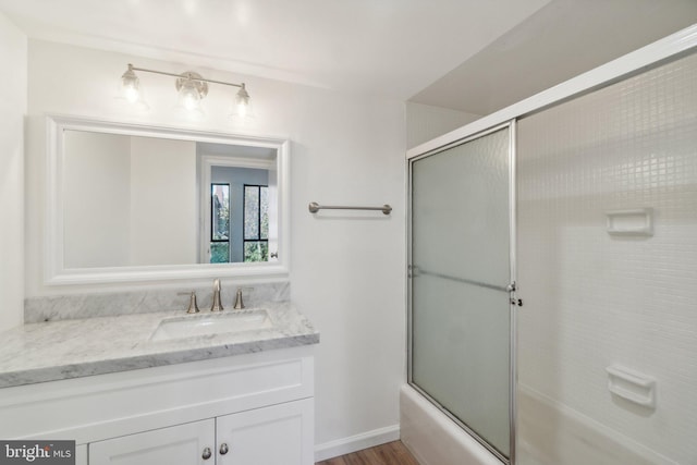 bathroom featuring shower / bath combination with glass door, vanity, and wood finished floors