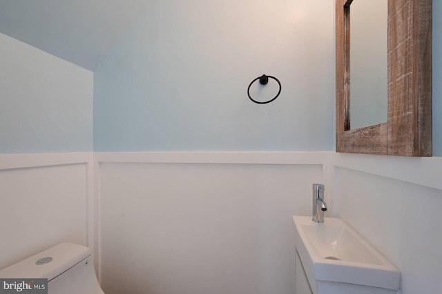 half bathroom featuring vanity and toilet