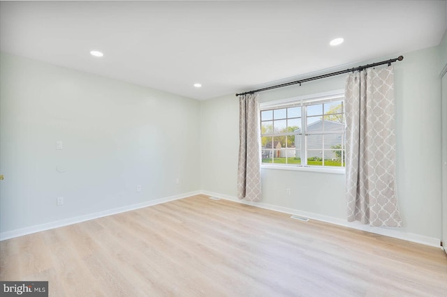 spare room featuring recessed lighting, wood finished floors, visible vents, and baseboards