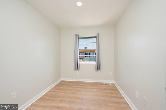 empty room with recessed lighting, light wood-type flooring, visible vents, and baseboards