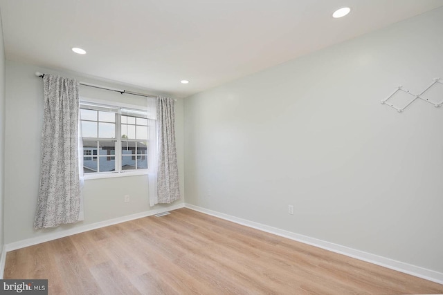 spare room with recessed lighting, wood finished floors, and baseboards
