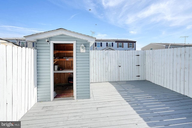 deck featuring a fenced backyard, an outbuilding, and a shed