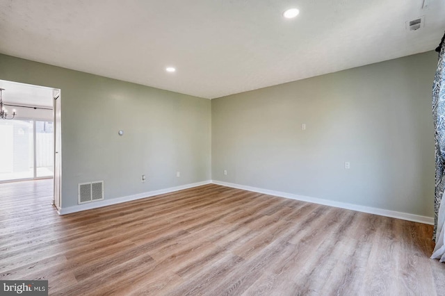 spare room featuring baseboards, wood finished floors, visible vents, and recessed lighting