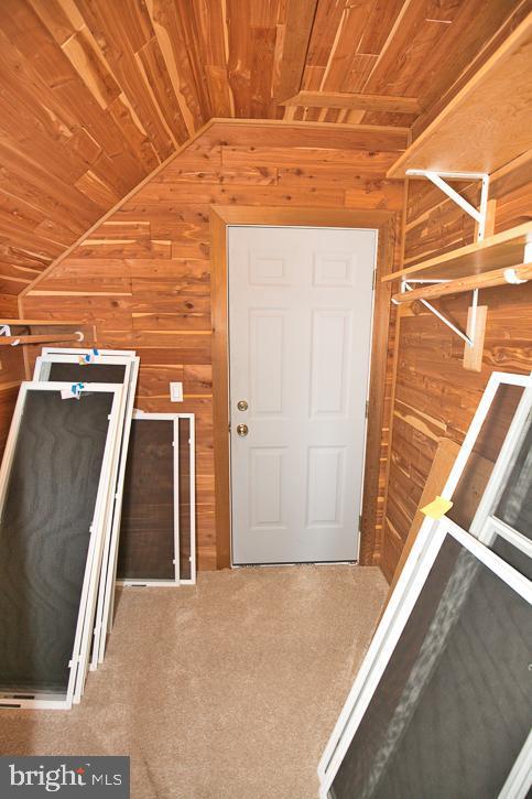 712 Riverside Pines Ct, Salisbury, MD 21801 - interior space with wood ceiling, wood walls, vaulted ceiling, and carpet