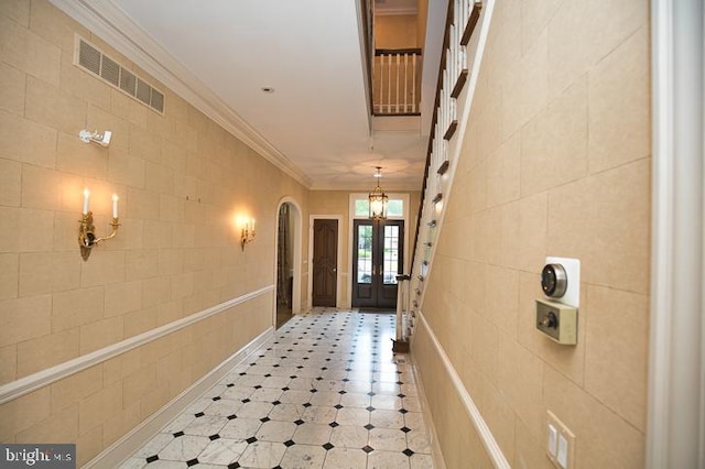712 Riverside Pines Ct, Salisbury, MD 21801 - hall featuring tile walls, arched walkways, french doors, a chandelier, and ornamental molding