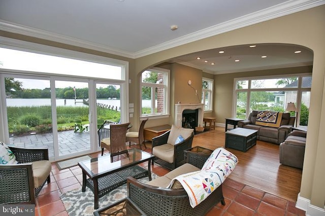 712 Riverside Pines Ct, Salisbury, MD 21801 - tiled living room featuring arched walkways, a fireplace, ornamental molding, baseboards, and a water view
