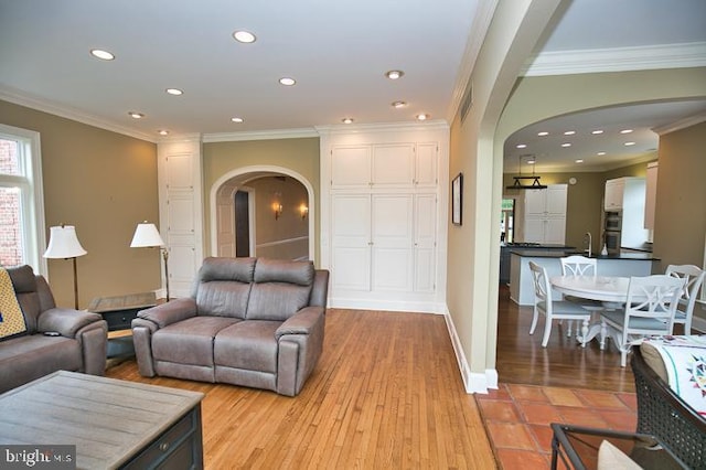 712 Riverside Pines Ct, Salisbury, MD 21801 - living room featuring arched walkways, light wood-style floors, crown molding, recessed lighting, and baseboards
