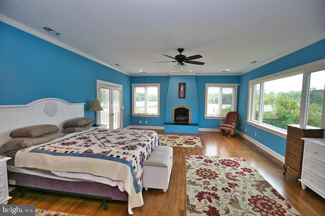 712 Riverside Pines Ct, Salisbury, MD 21801 - bedroom with crown molding, wood finished floors, baseboards, and a fireplace with raised hearth