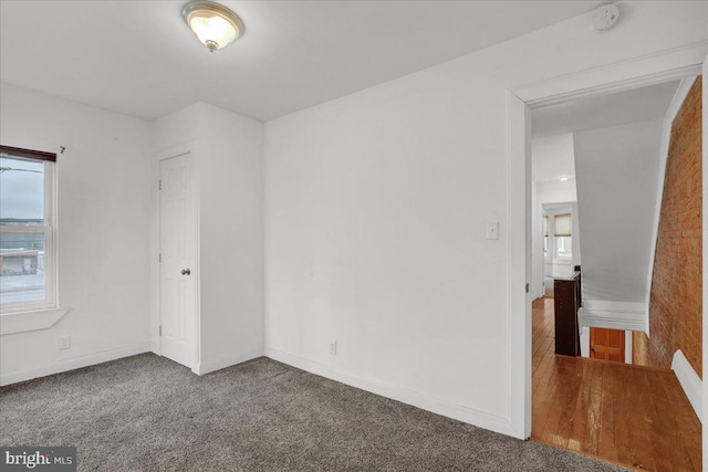 carpeted spare room featuring baseboards