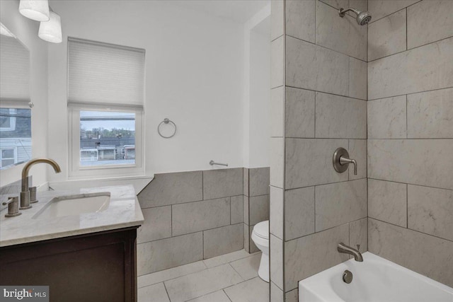 full bath featuring vanity, tile patterned flooring, toilet, tile walls, and tub / shower combination