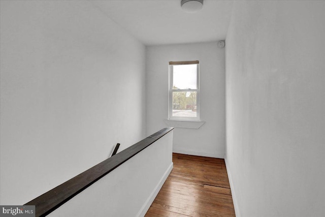 hall featuring baseboards and hardwood / wood-style floors