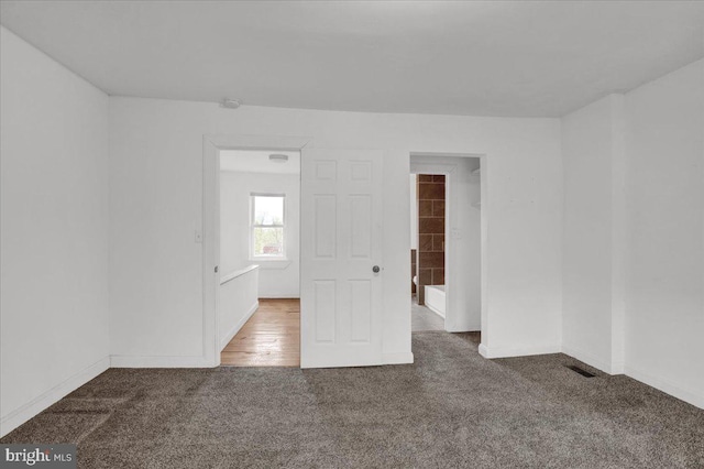 carpeted spare room featuring visible vents