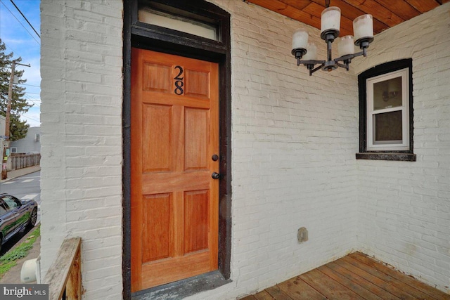 view of exterior entry featuring brick siding