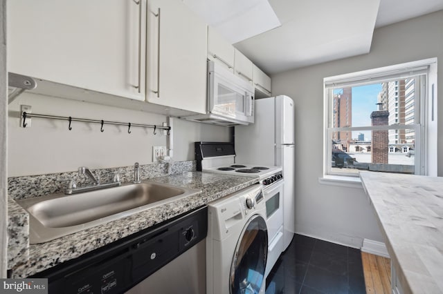 kitchen featuring washer / clothes dryer, white cabinets, a sink, white microwave, and range