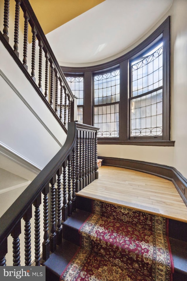 stairway with baseboards and wood finished floors