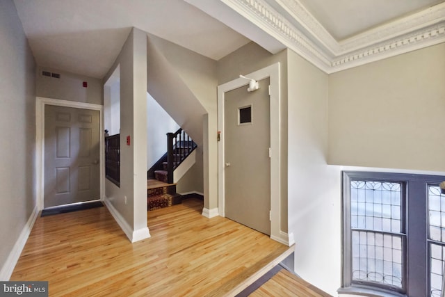 entryway with light wood-style floors, baseboards, visible vents, and stairs