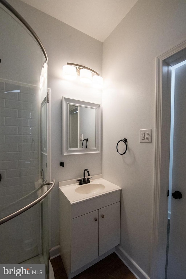 full bath featuring baseboards, a shower stall, and vanity