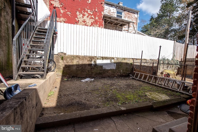 view of yard featuring stairs and fence