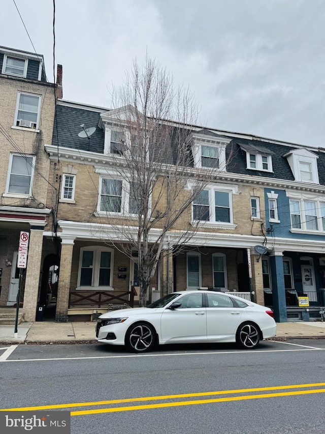 multi unit property featuring a shingled roof and mansard roof