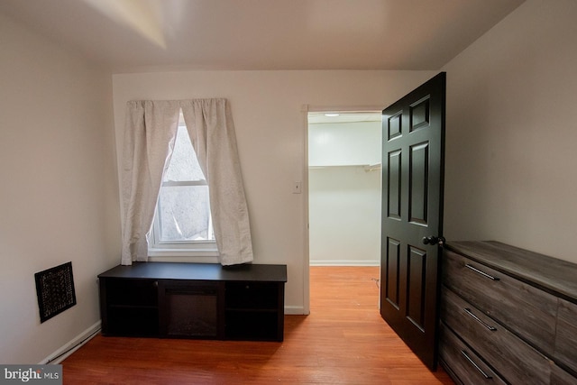 interior space featuring baseboards and light wood finished floors