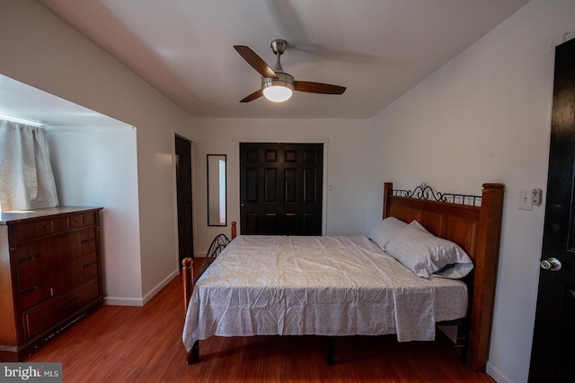 bedroom with a closet, baseboards, a ceiling fan, and wood finished floors