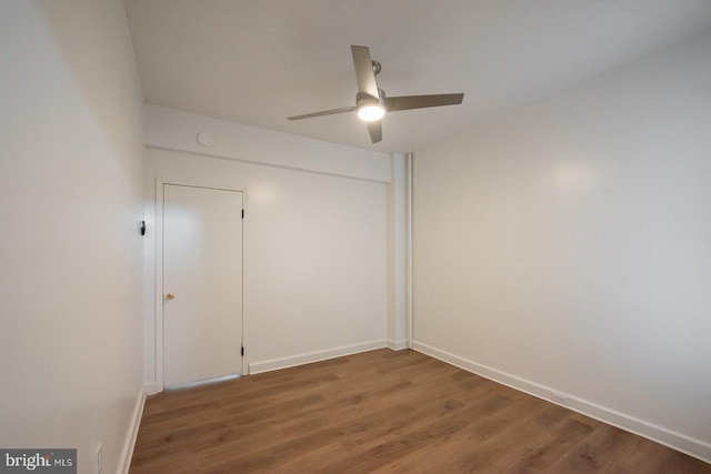 spare room with wood finished floors, baseboards, and a ceiling fan
