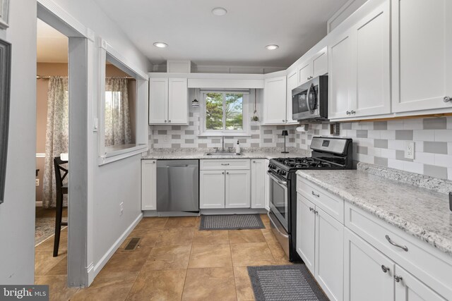 14 Cedar Ct, Flemington, NJ 08822 - kitchen featuring stainless steel appliances, a sink, white cabinets, decorative backsplash, and light stone countertops