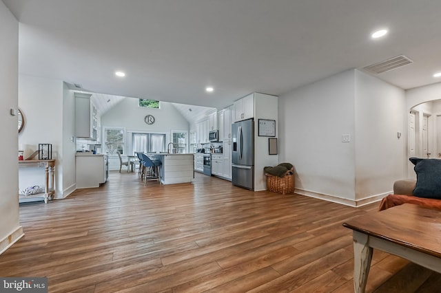 204 Canal St, Grasonville, MD 21638 - living room featuring visible vents, arched walkways, recessed lighting, vaulted ceiling, and wood finished floors