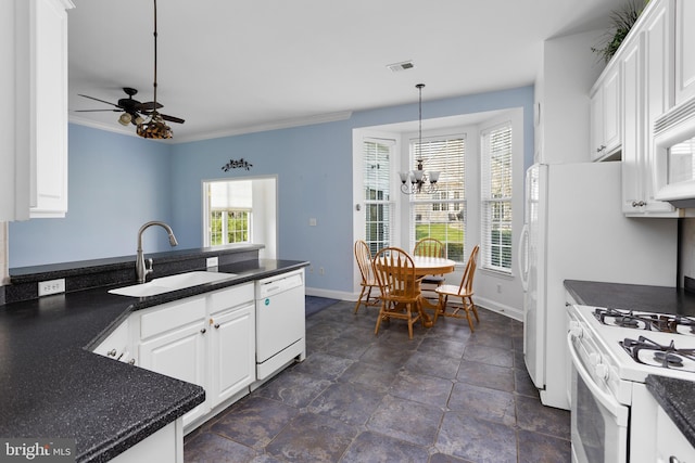 kitchen with white appliances, baseboards, a sink, and dark countertops