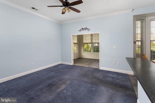 spare room with crown molding, baseboards, a ceiling fan, and visible vents