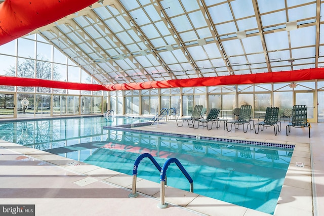 community pool featuring a patio and glass enclosure