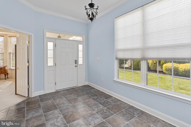 entrance foyer featuring a chandelier, baseboards, ornamental molding, and stone finish flooring