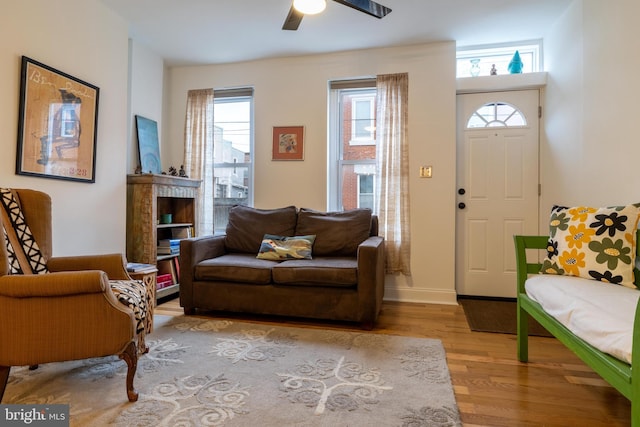 interior space featuring wood finished floors, baseboards, a ceiling fan, and a wealth of natural light